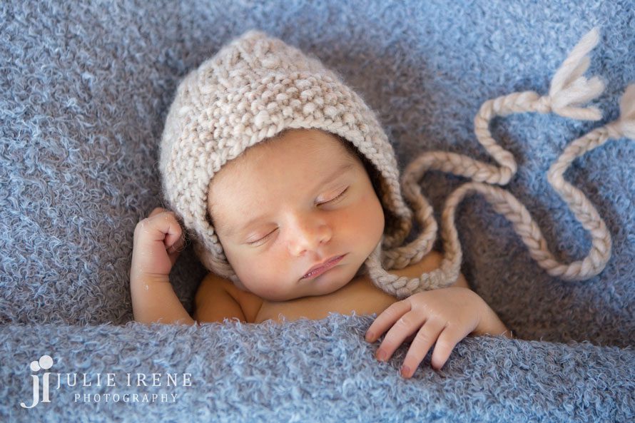 baby in a blanket with knit hat