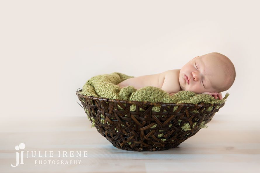 green newborn boy in bucket