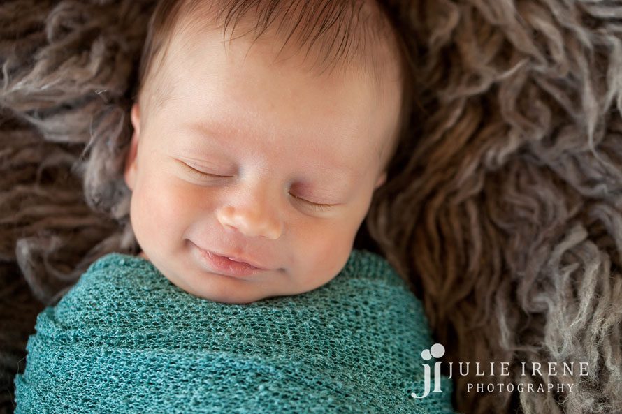 sweet smile with teal baby wrap newborn photo