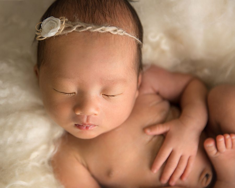 close up of newborn girl on cream