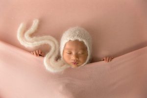 large cream bonnet on a little baby girl
