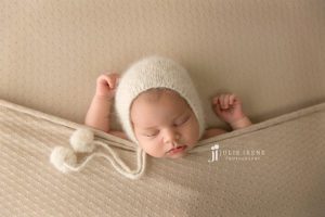 cream newborn girl sleeping with hands up