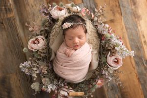 newborn girl wrapped in pink with florals
