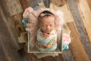 baby girl wrapped in a floral wrap with flowers
