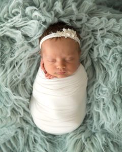 baby girl in cream wrap on luneberry flokati