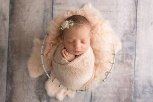 wrapped girl in cream and peach newborn floral headband