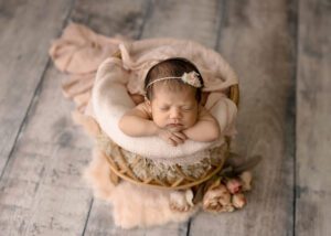 little newborn girl in a cute basket