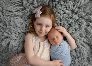 a beautiful sister with her newborn brother