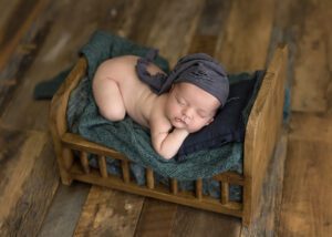 a little baby boy sleeping in a wooden bed