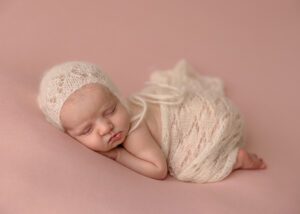 dainty newborn girl in pink and cream