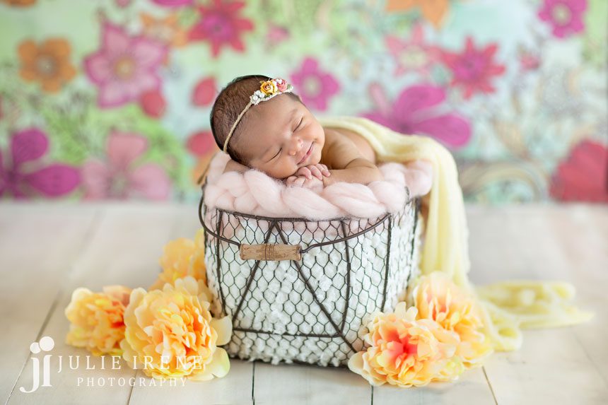 flower background newborn photo posed flowers smiling baby