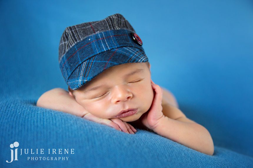 cute hat newborn baby hand on cheek blues photo