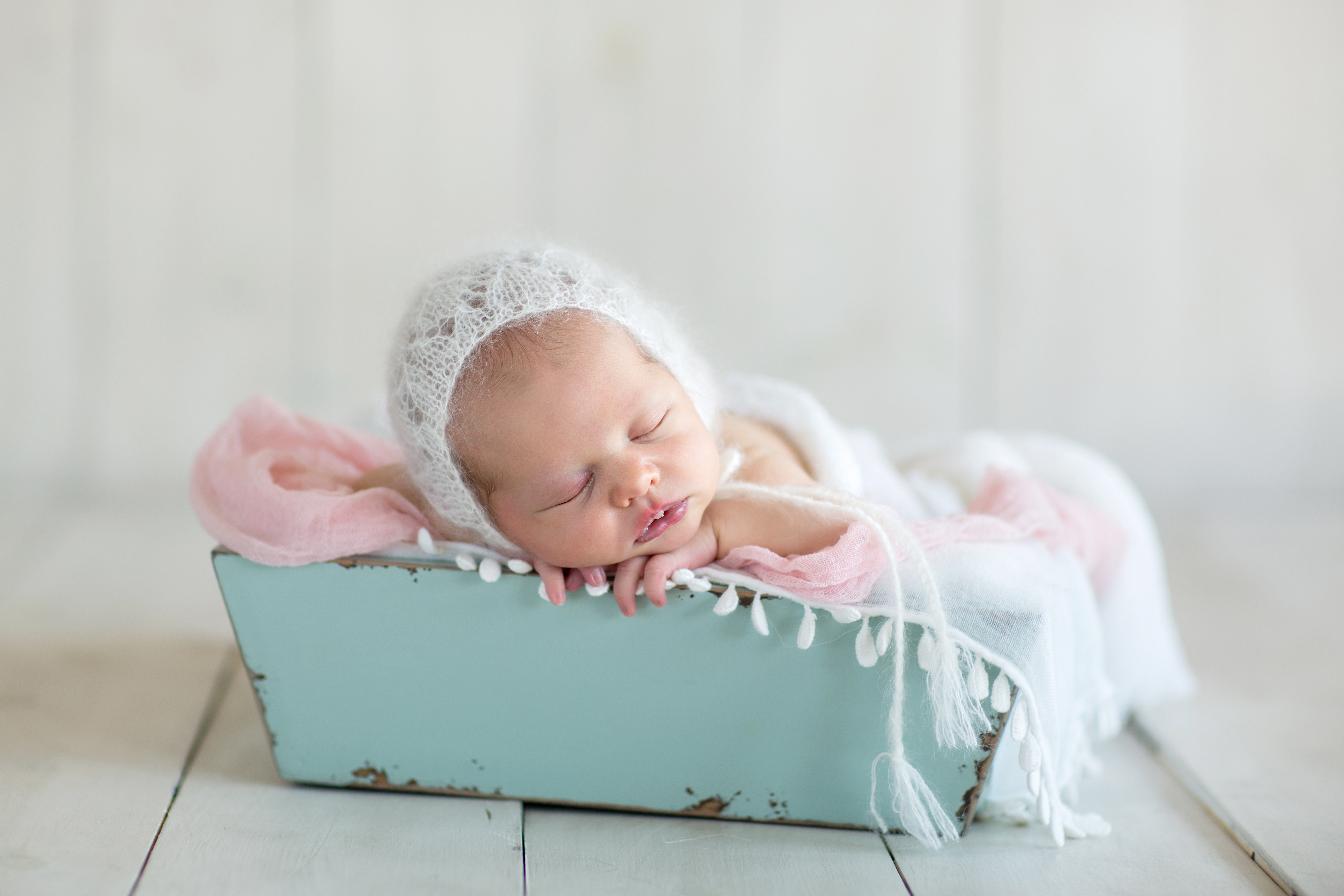 baby in crate blue pink white photo