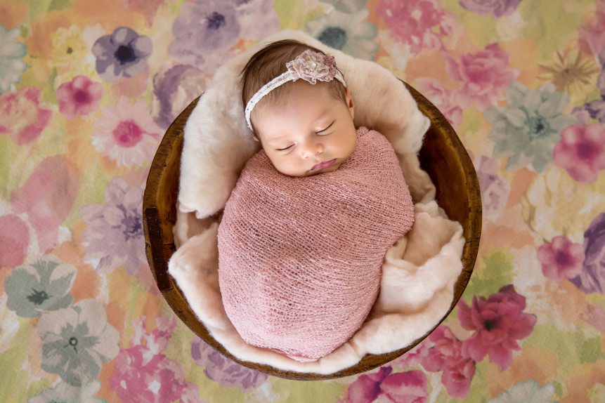 floral backdrop swaddled newborn baby