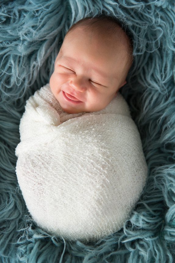 baby sweet smile swaddled newborn photo