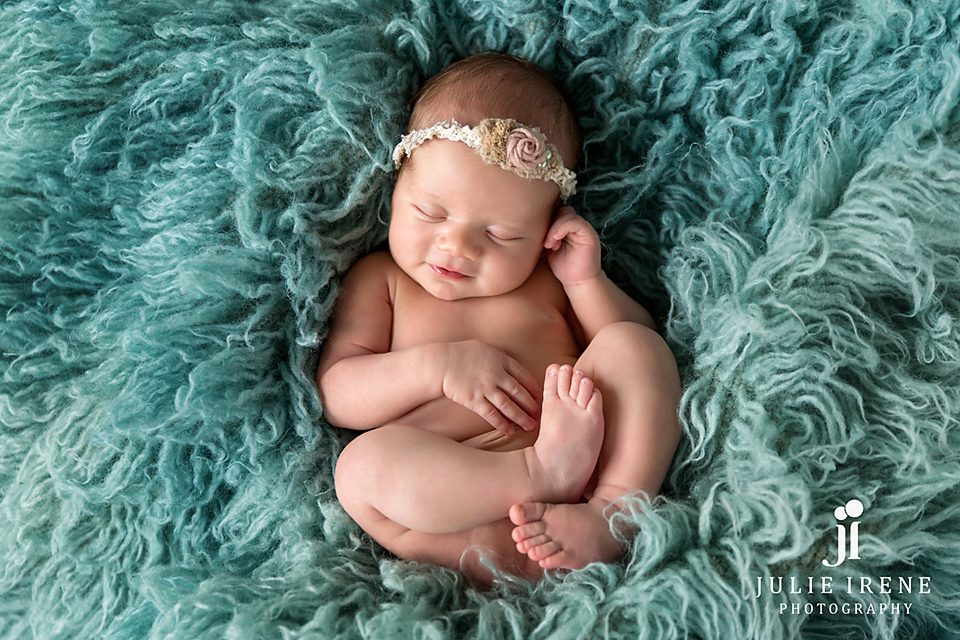 newborn girl with sweet smile julie irene on flokati
