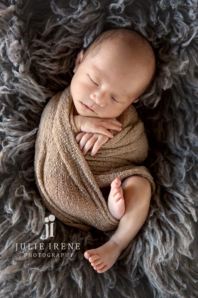 newborn baby boy wrapped with feet showing