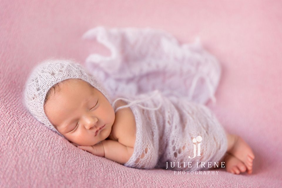newborn girl all wrapped in lavendar on pink in orange county