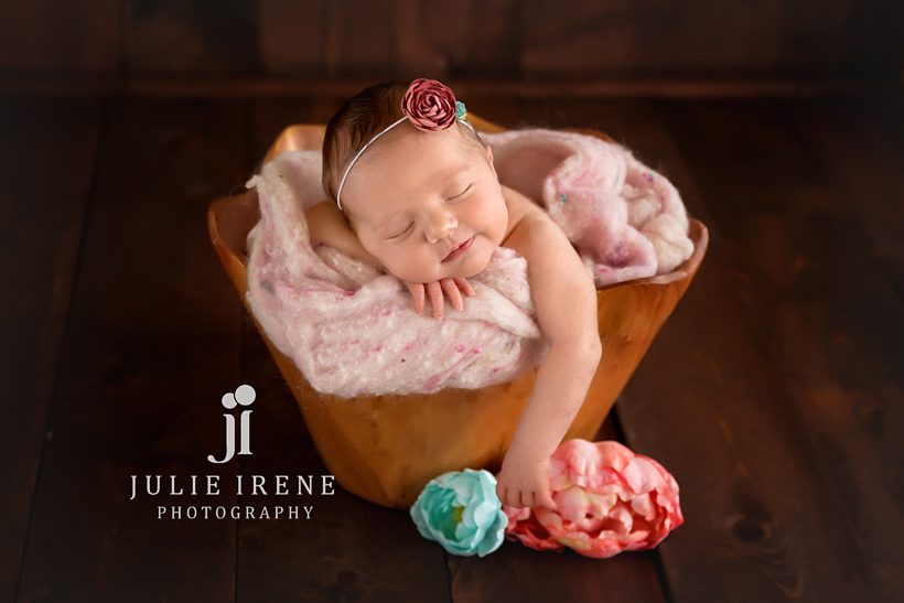 newborn girl in wood bucket with smile in san clemente