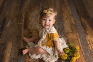 baby with yellow flowers and yellow mia joy outfit
