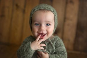 surprised boy in a knit green outfit