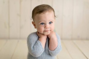 blue eyes to match the blue knit outfit of baby boy portrait