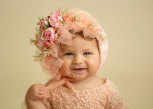 close up of a baby wearing a floral bonnet