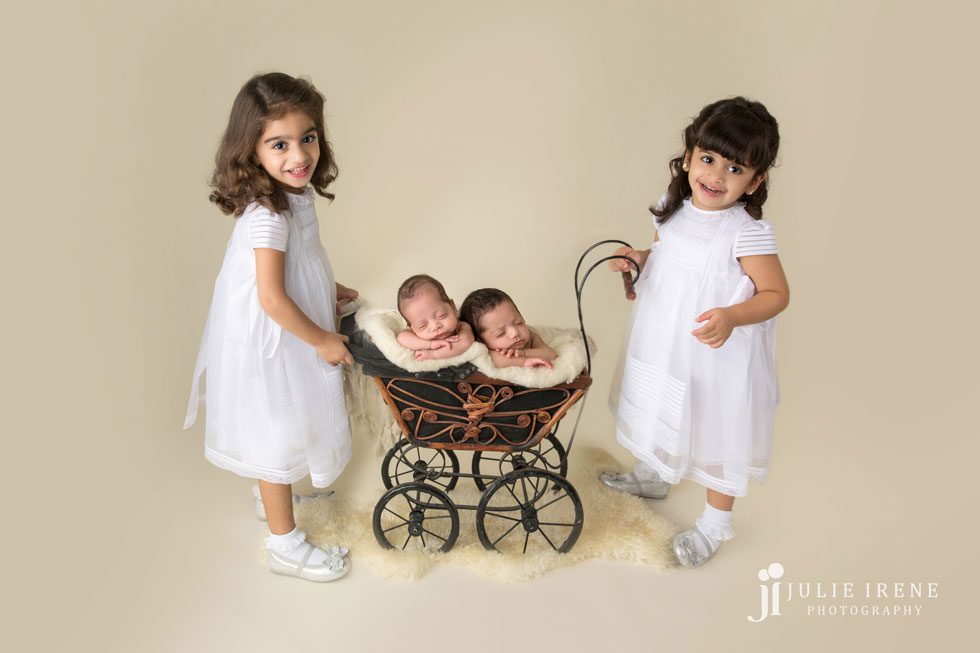 newborn twins in baby carriage with twins