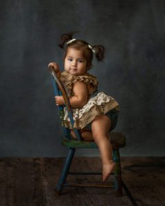 first birthday girl on chair portrait