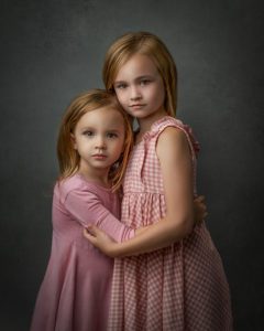 two young sisters hugging in pink