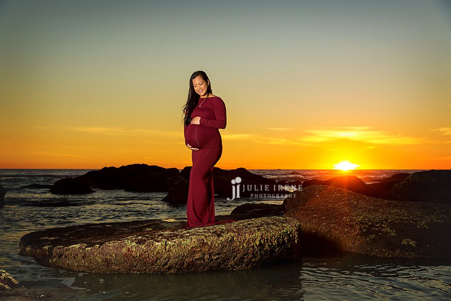 maternity portrait during sunset on a rock
