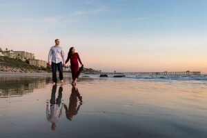 couple walking on beach during low tide