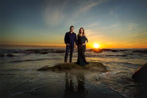 couple standing on rock in ocean