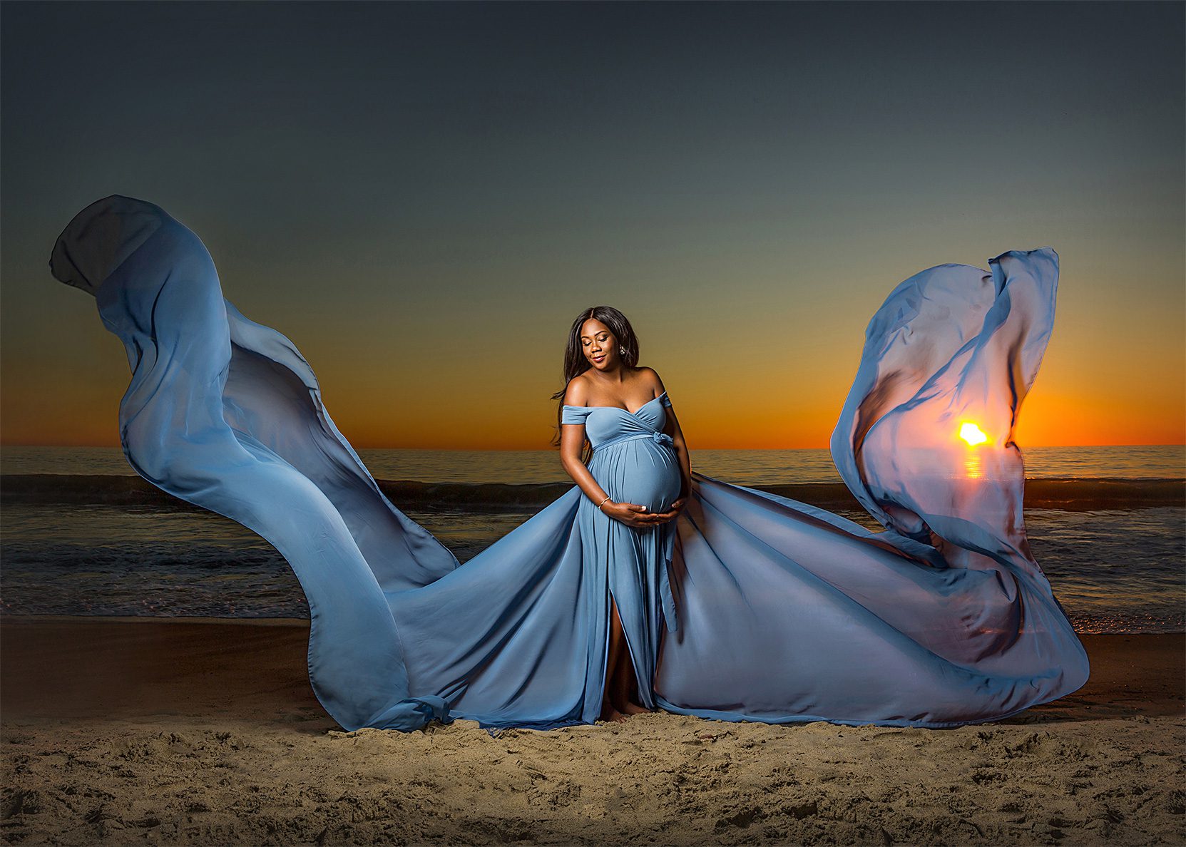 flowing dress on pregnant mom at sunset
