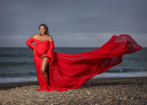 pregnant woman in red on beach