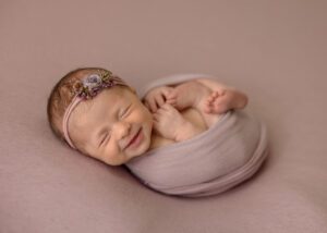 smiling newborn girl in pink