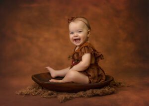 very happy baby girl in orange mia joy outfit