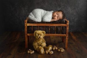 colored baby with bears on wood cradle